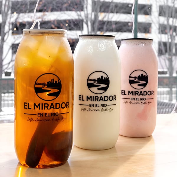 Three El Mirador En El Rio branded drinks: iced tea, horchata, and a pink beverage.
